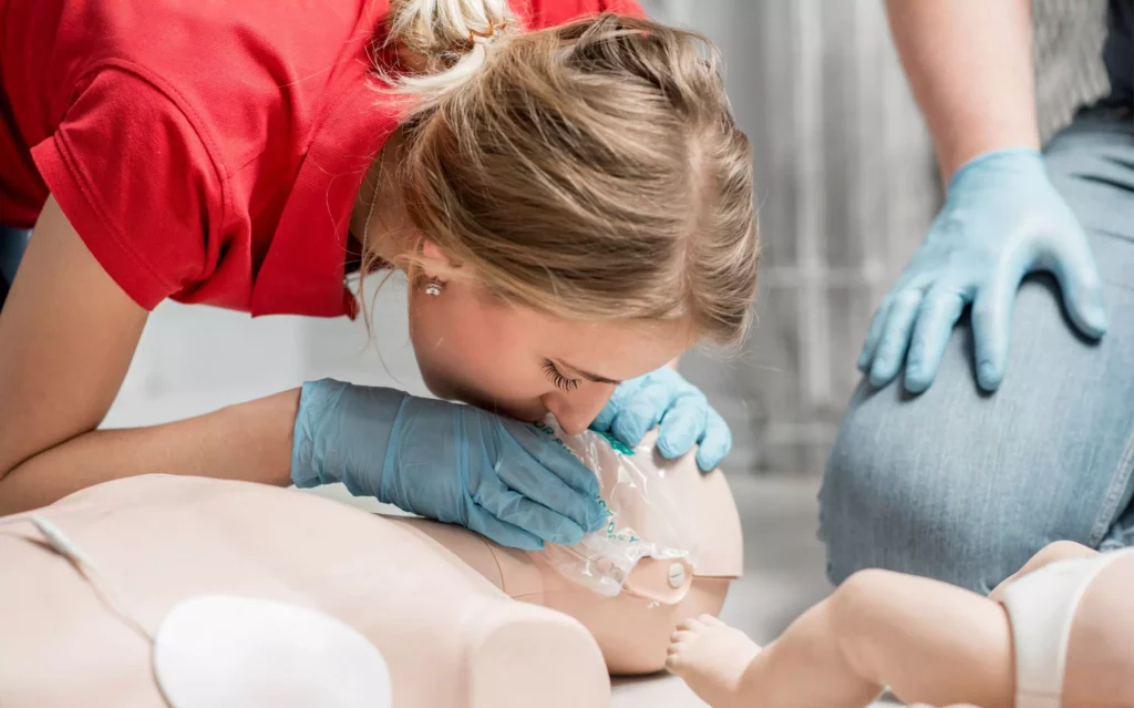 une femme pratique des insufflation sur un manequin pour illustrer l'article sur le prix formation SST