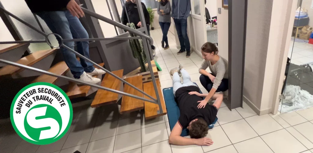 Une femme s'exerce sur une personne qui a fait une chute dans un escalier pendant une formation SST Nérac