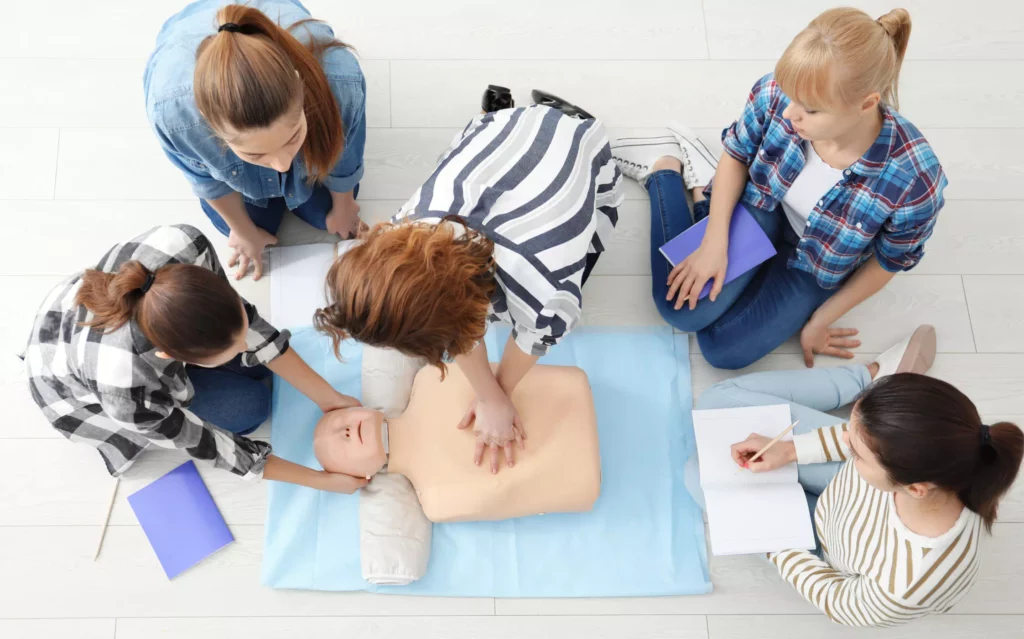 Des personnes pratiquent le massage cardiaque en suivant le programme de la formation SST