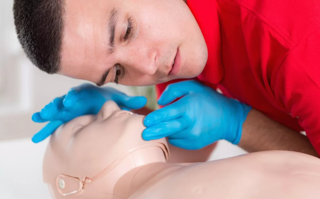 Après avoir appris comment se passe la formation SST, un homme fait des exercices de secourisme