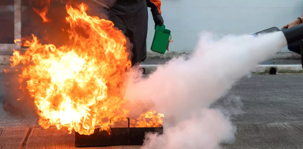 Un stagiaire éteint un feu lors d'une formation manipulation extincteur