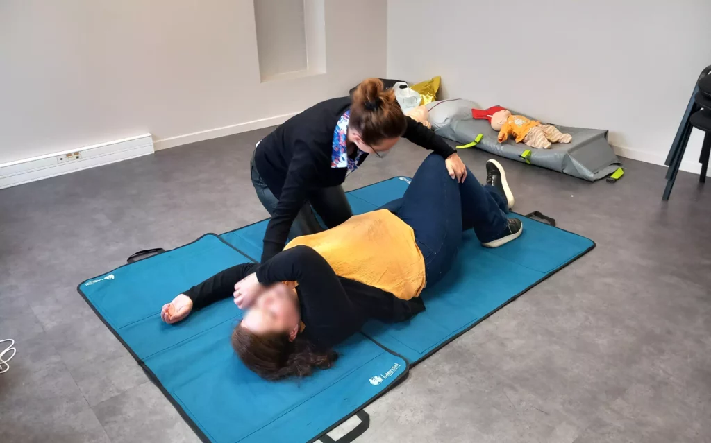 Pendant une formation SST, une apprenante apprend les gestes de premiers secours