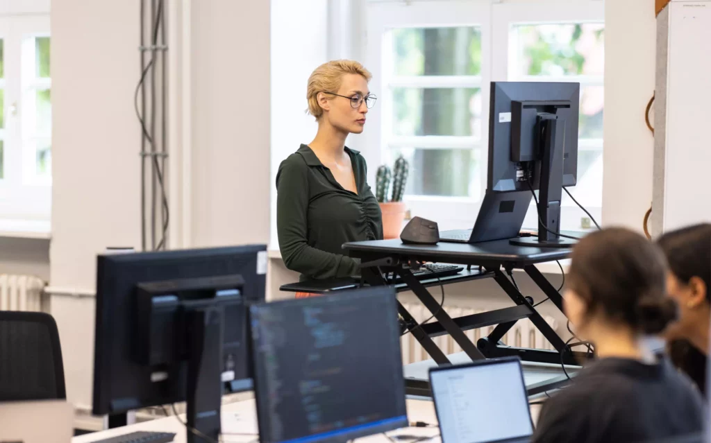 Une femme a bien travaillé l'Ergonomie de son poste de travail avec du matériel adapté