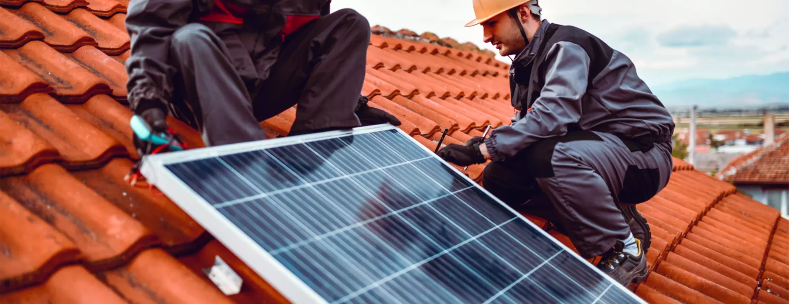 Deux personnes formées à l'habilitation BP pose des panneaux photovoltaïque sur le toit d'une maison